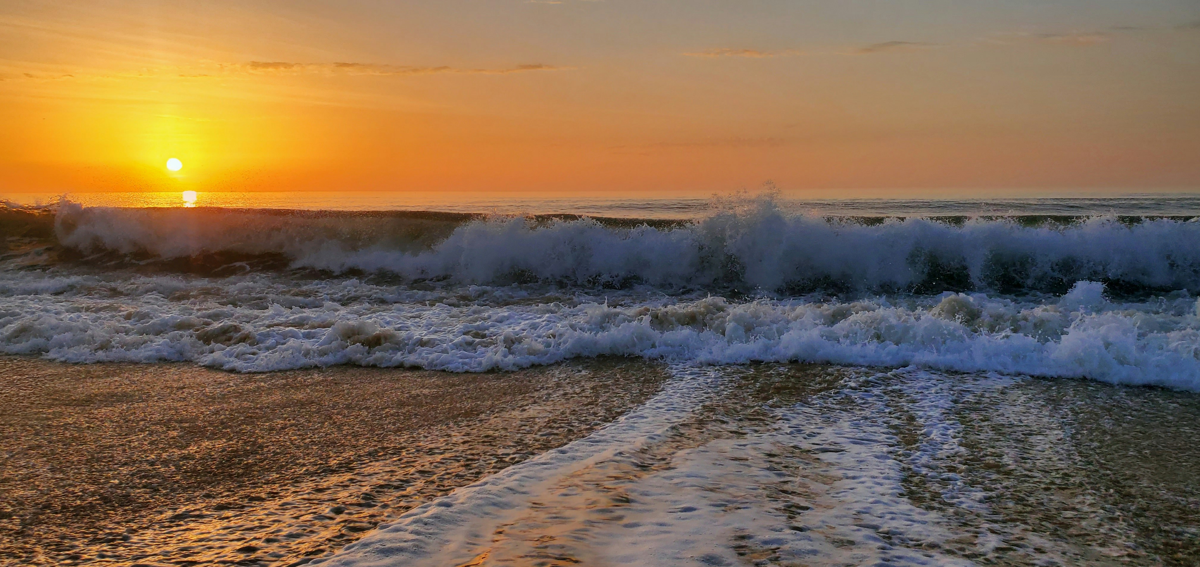 The sun is setting over the ocean waves
