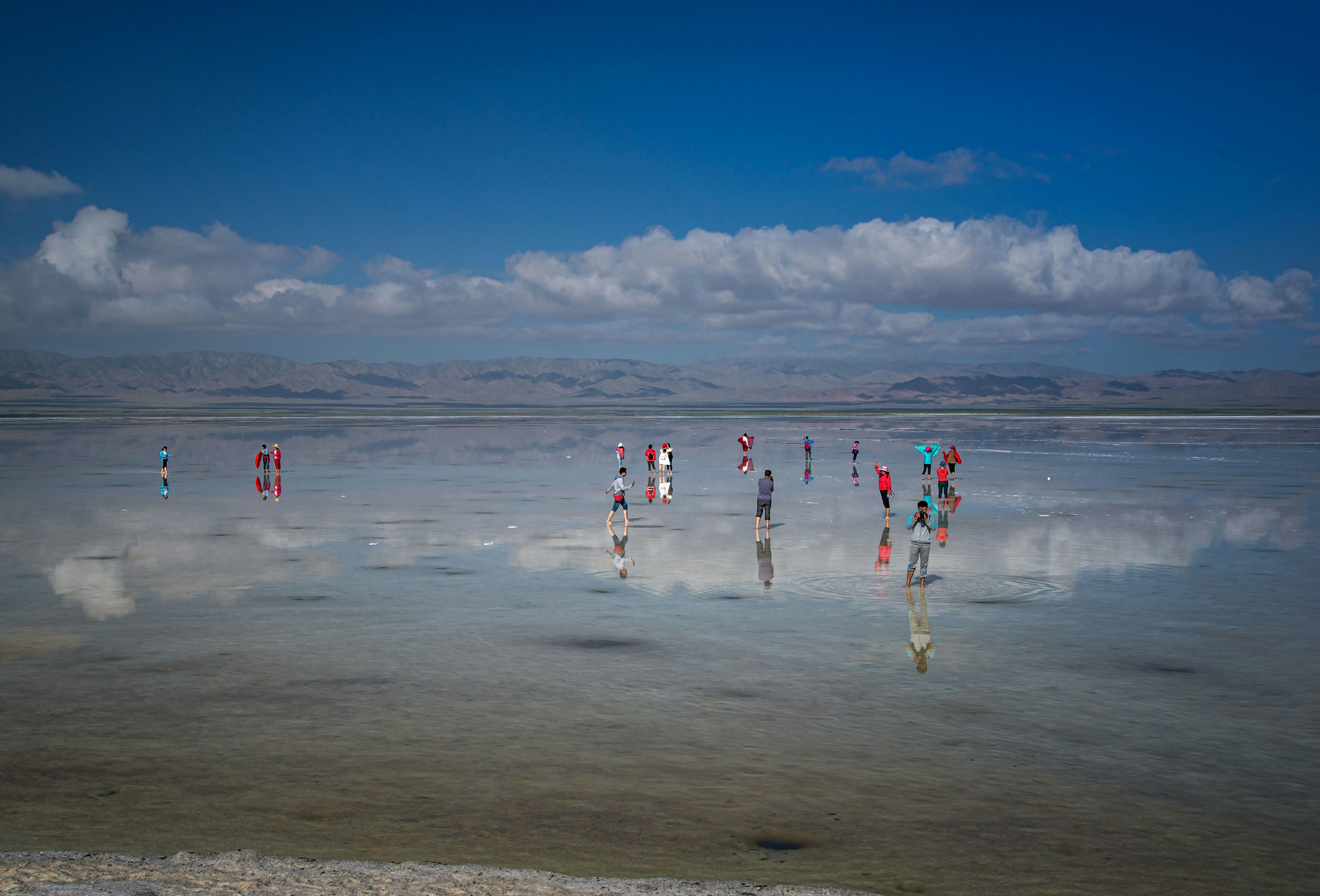 水域の真ん中に立っている人々のグループ