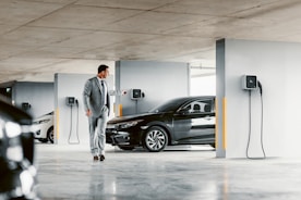 A man in a suit walking towards a car