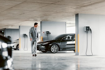 A man in a suit walking towards a car
