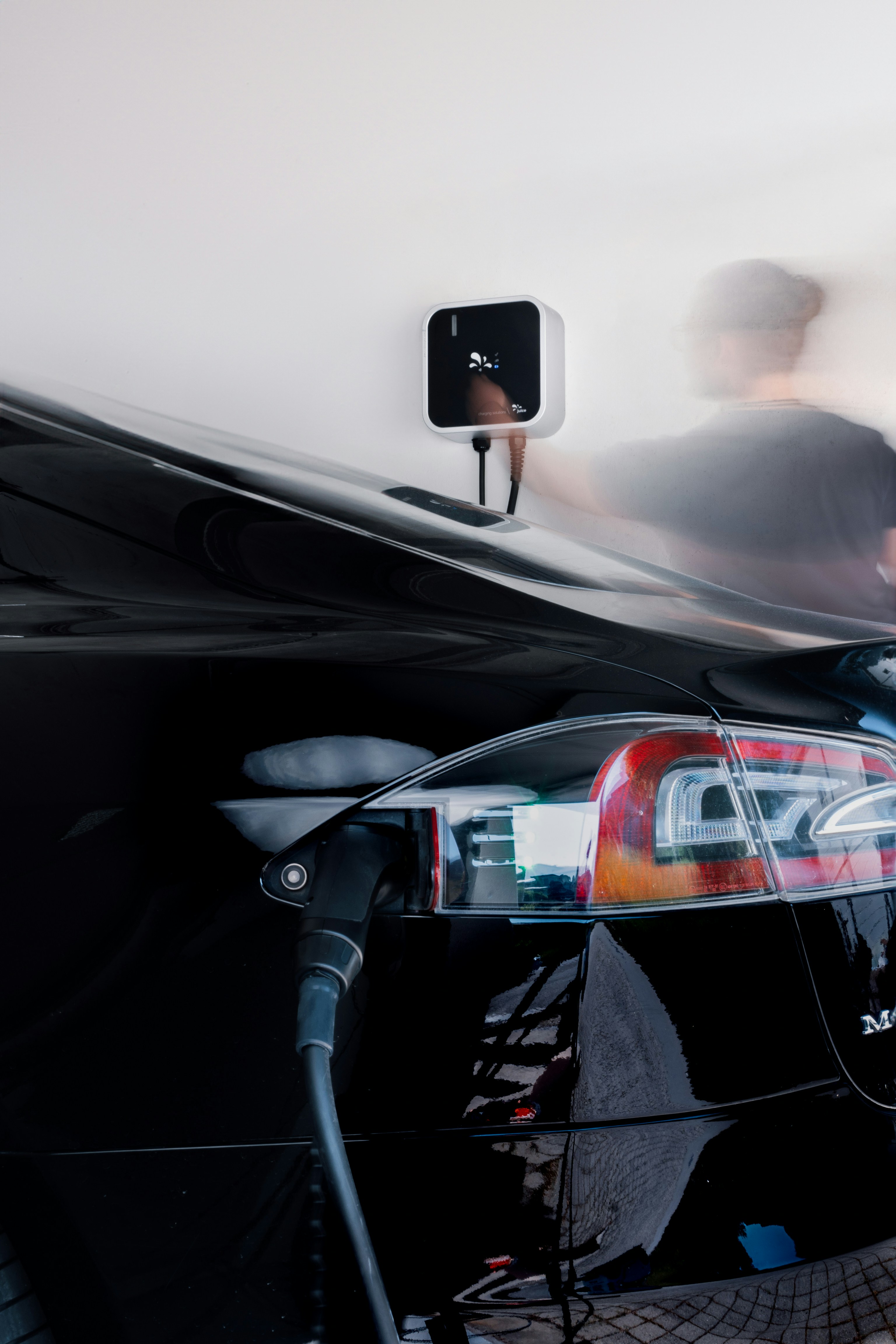 A man is standing next to a black car