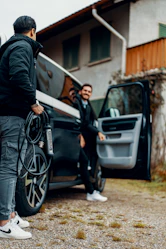 A couple of men standing next to a van