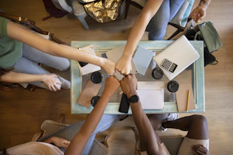A group of people holding hands over a table