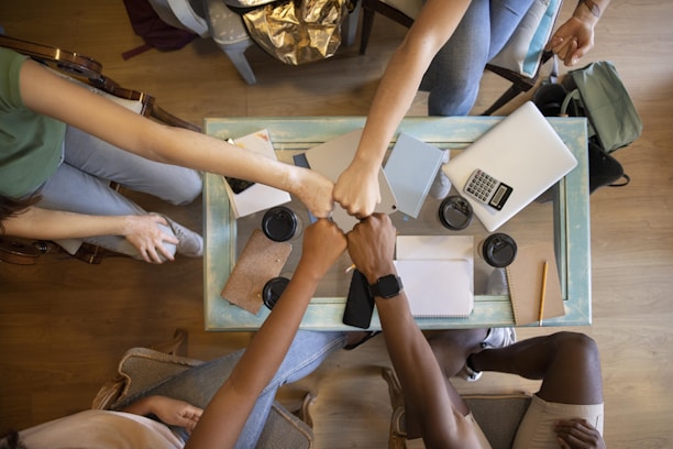 A group of people holding hands over a table