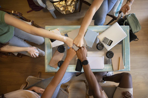 A group of people holding hands over a table