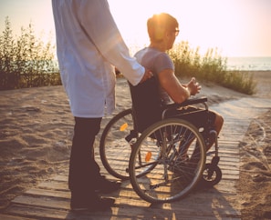 A man in a wheel chair on the beach