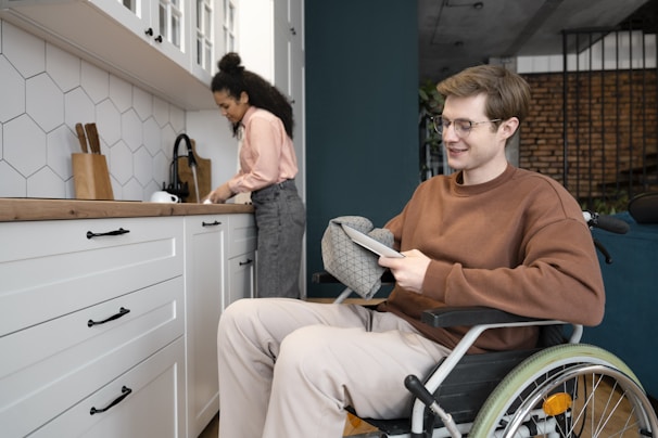 A man in a wheel chair in a kitchen