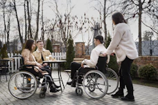 A group of people in wheelchairs sitting around a table