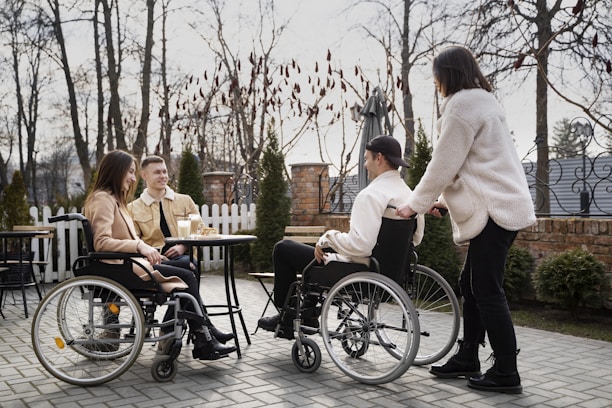 A group of people in wheelchairs sitting around a table