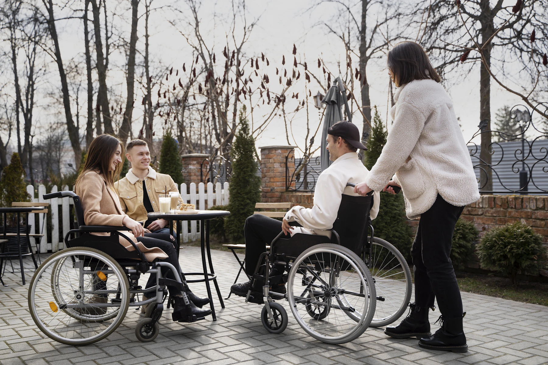 A group of people, some using wheelchairs, sharing an activity around a table