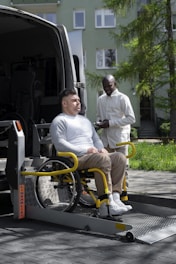 A man sitting in a wheelchair next to a van