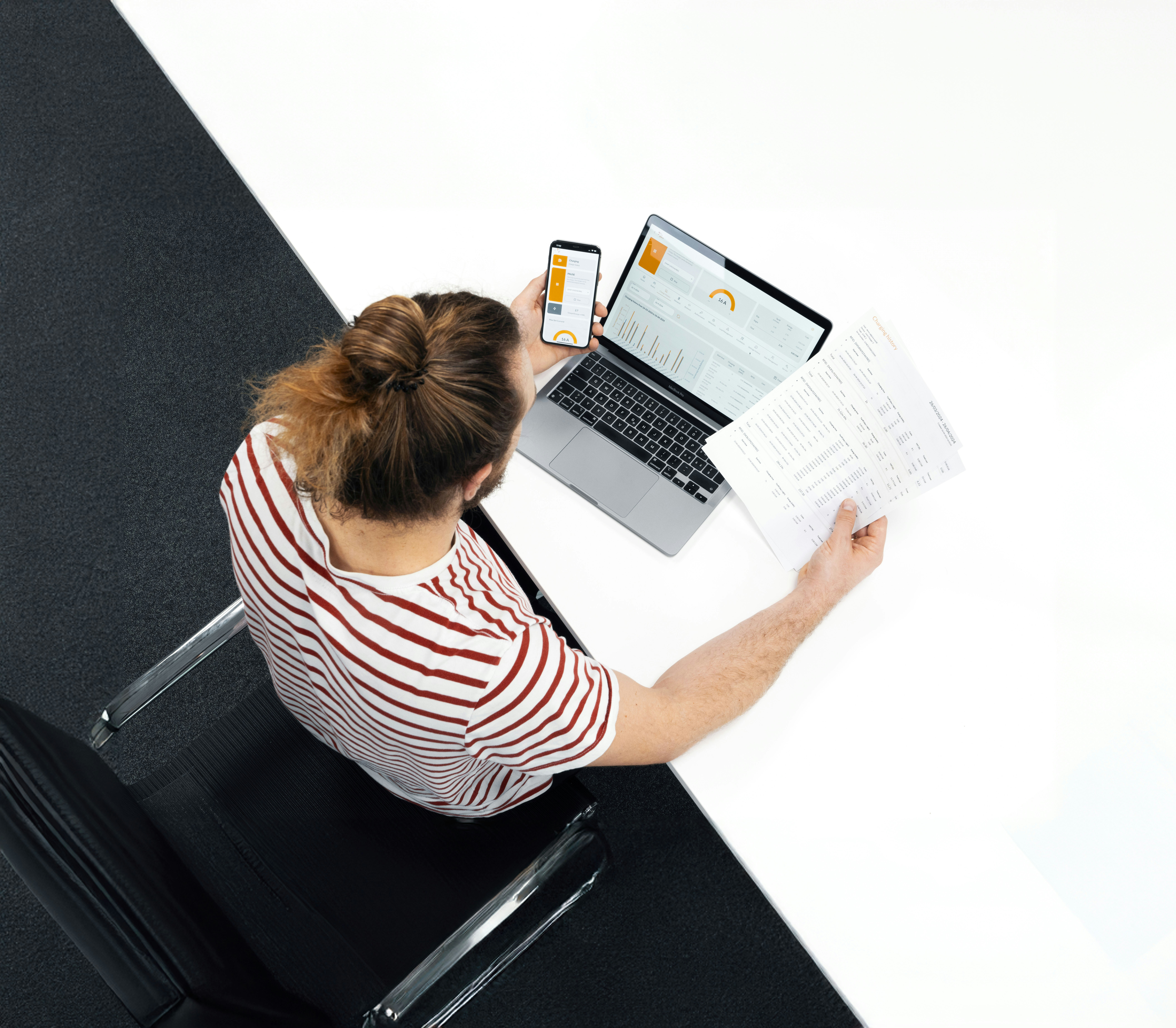 A woman sitting at a desk with a laptop and papers