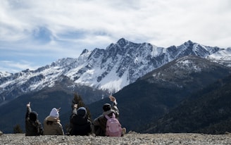 A group of people sitting on top of a mountain