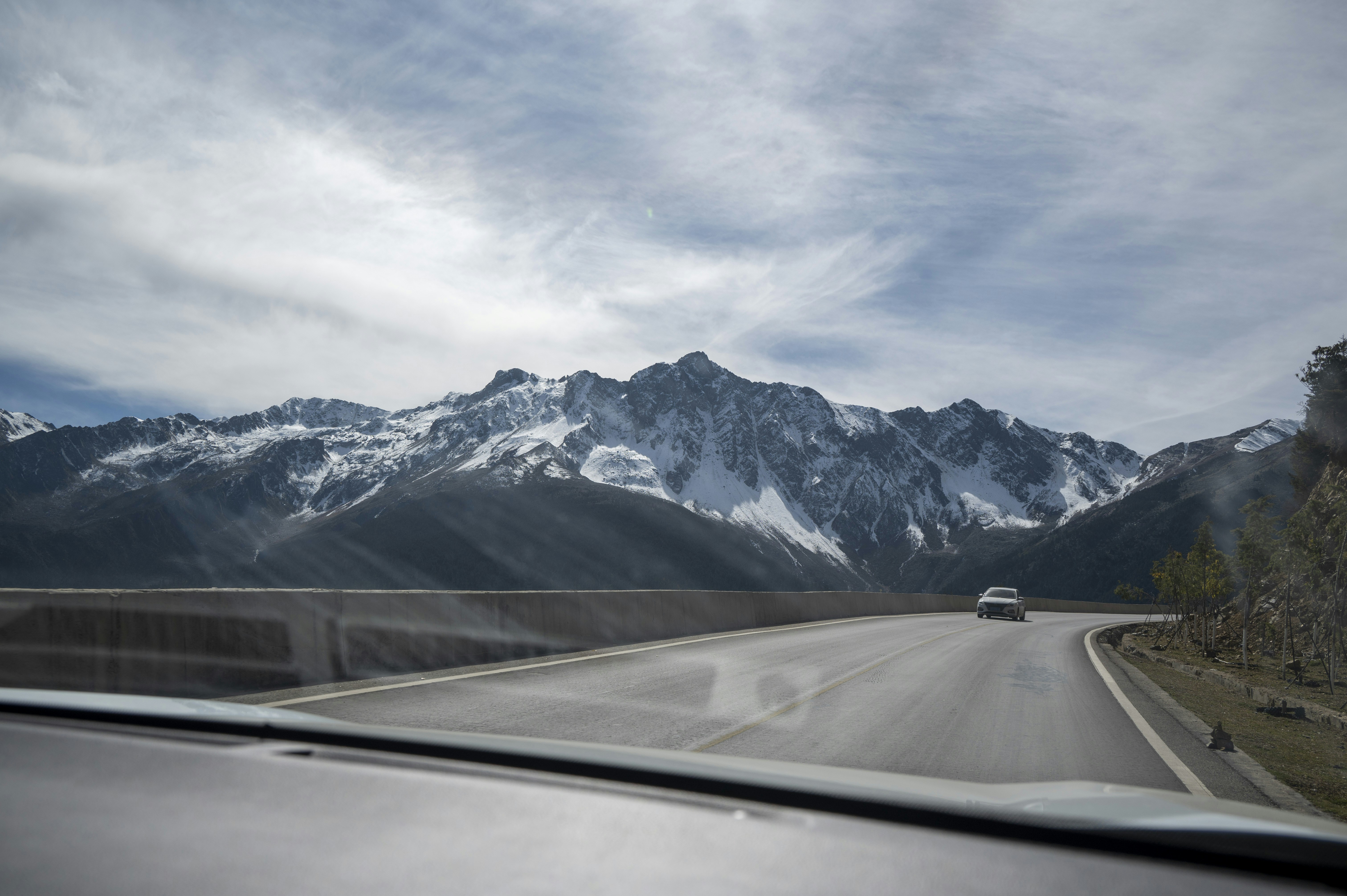 A car driving down a road with mountains in the background