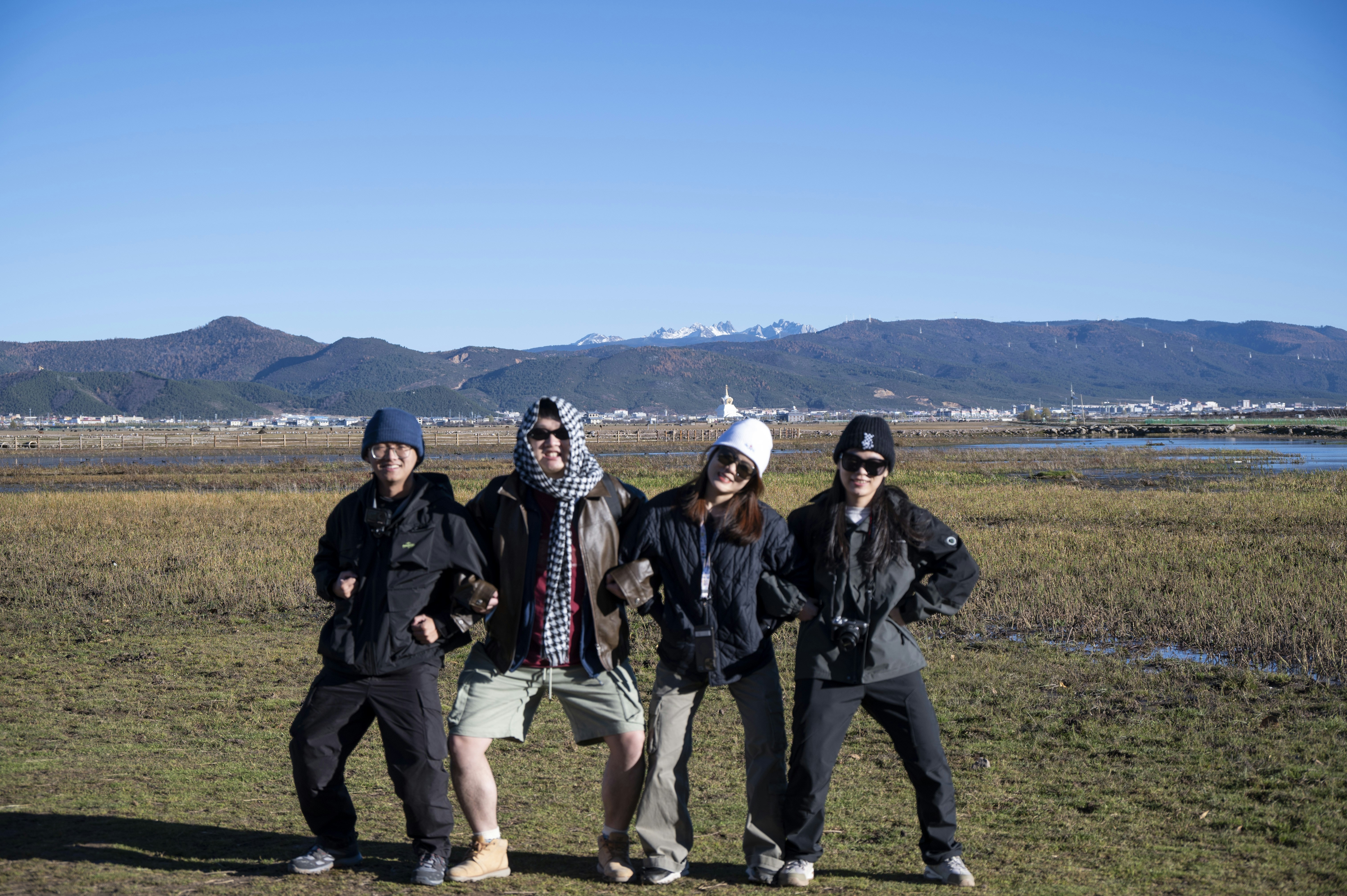 A group of pilgrims, looking relieved, posing in front of a scenic mountain backdrop after safely landing.
