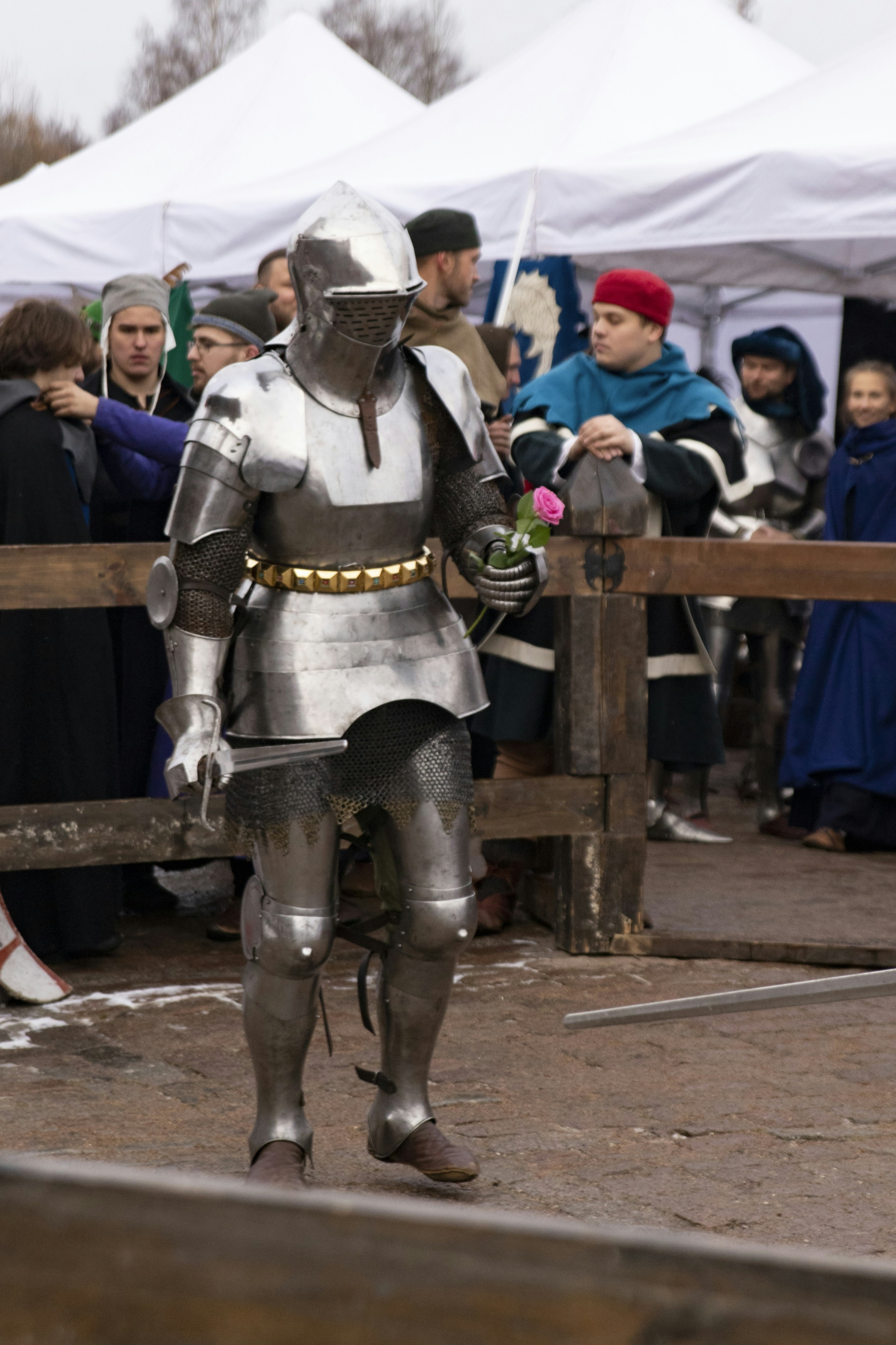 A man in a suit of armor standing in front of a crowd