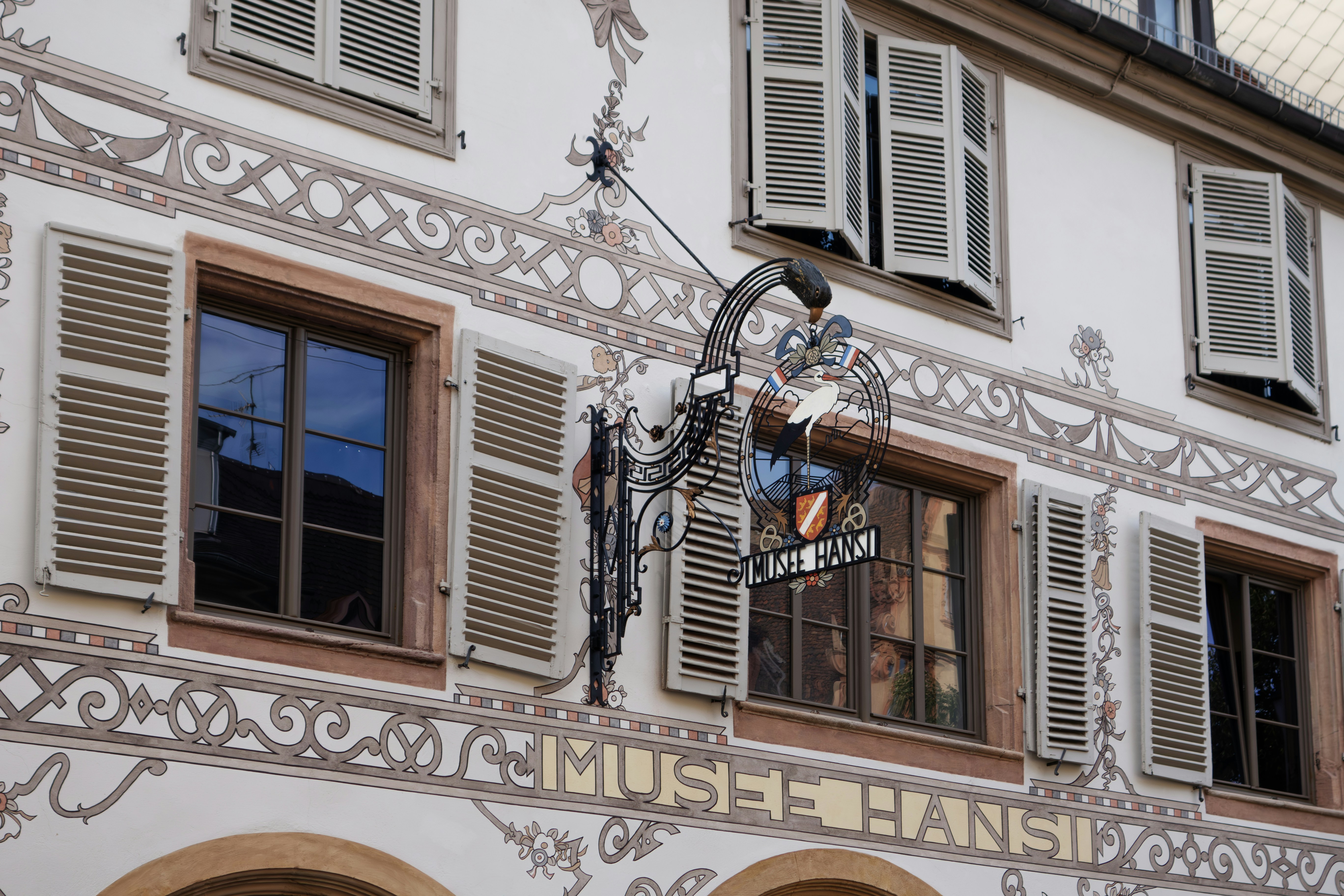 A tall white building with lots of windows, La magnifique architecture des maisons de la ville alsacienne de Colmar.