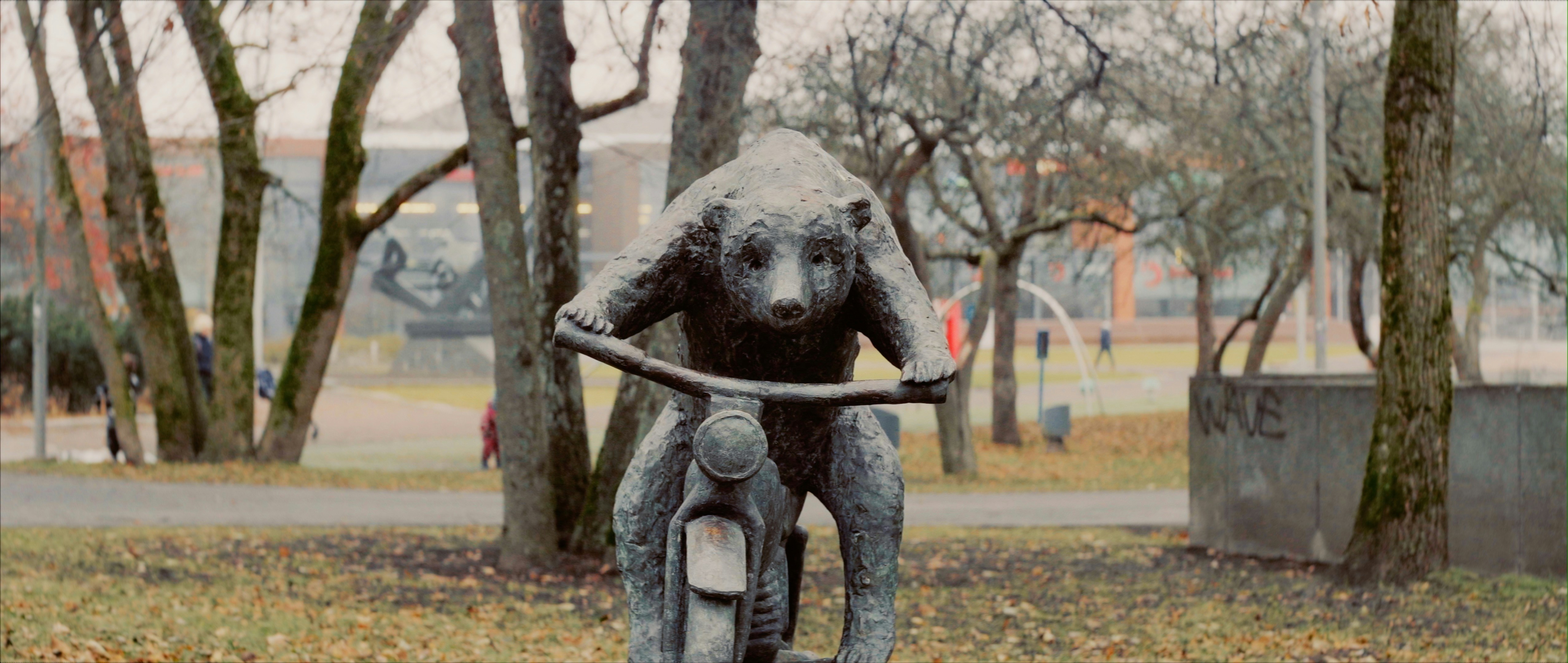 Eine Statue eines Mannes, der in einem Park Fahrrad fährt