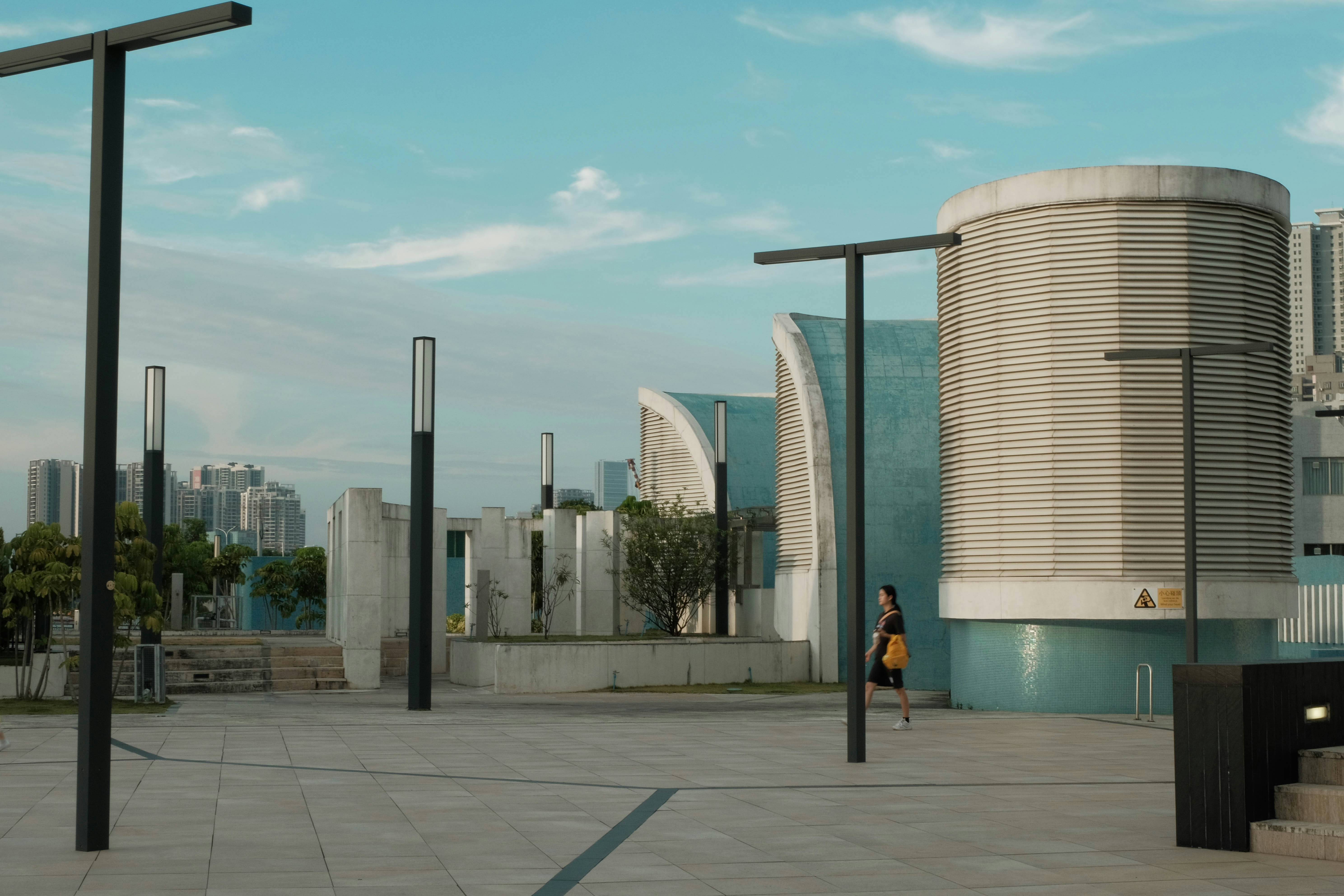 A person walking down a street next to a tall building