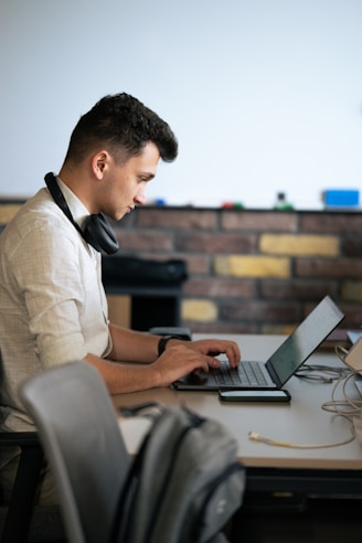 A man sitting at a table using a laptop computer