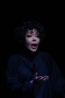 A woman in a black shirt is holding her hands out