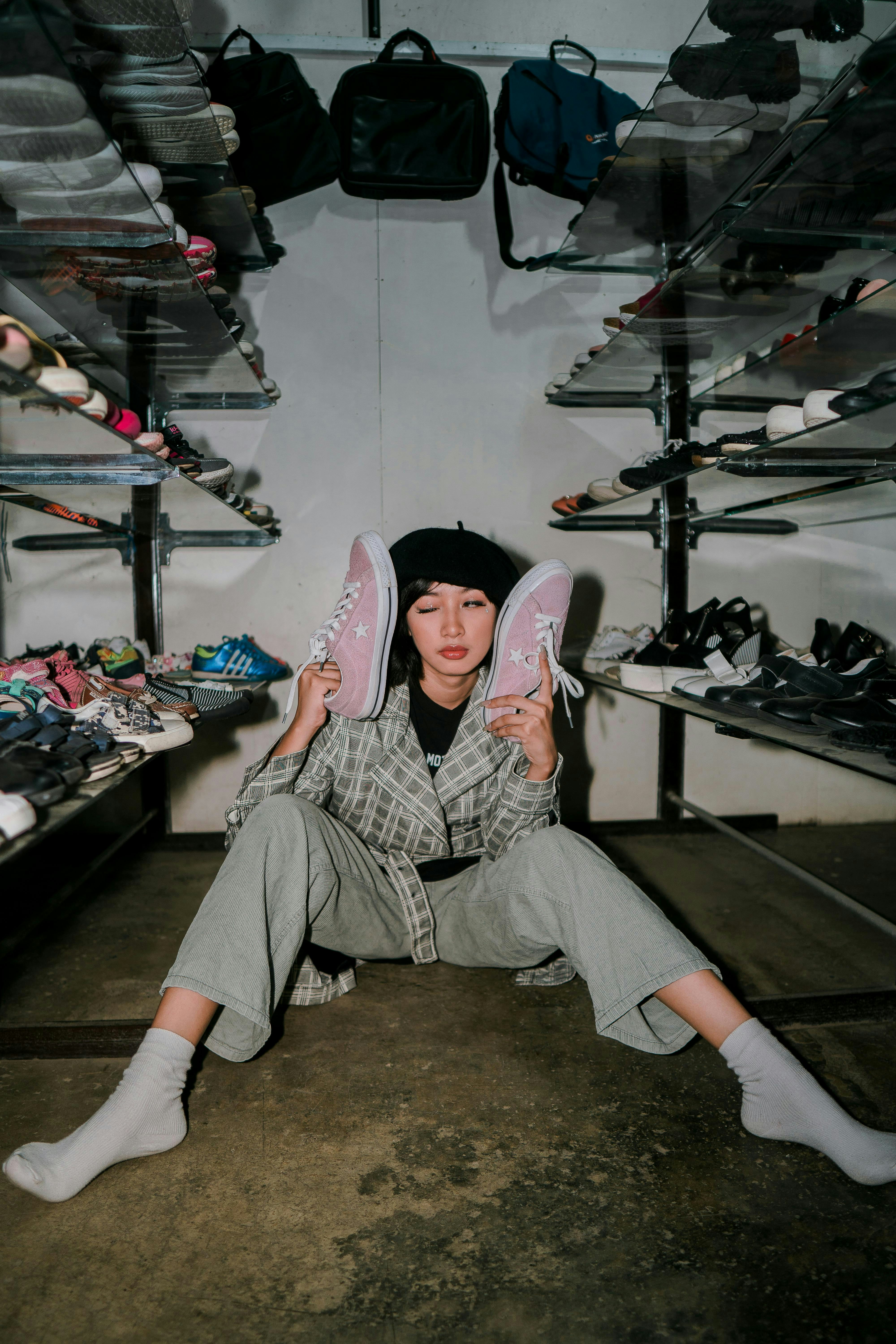 A person sitting on the ground holding a pair of shoes