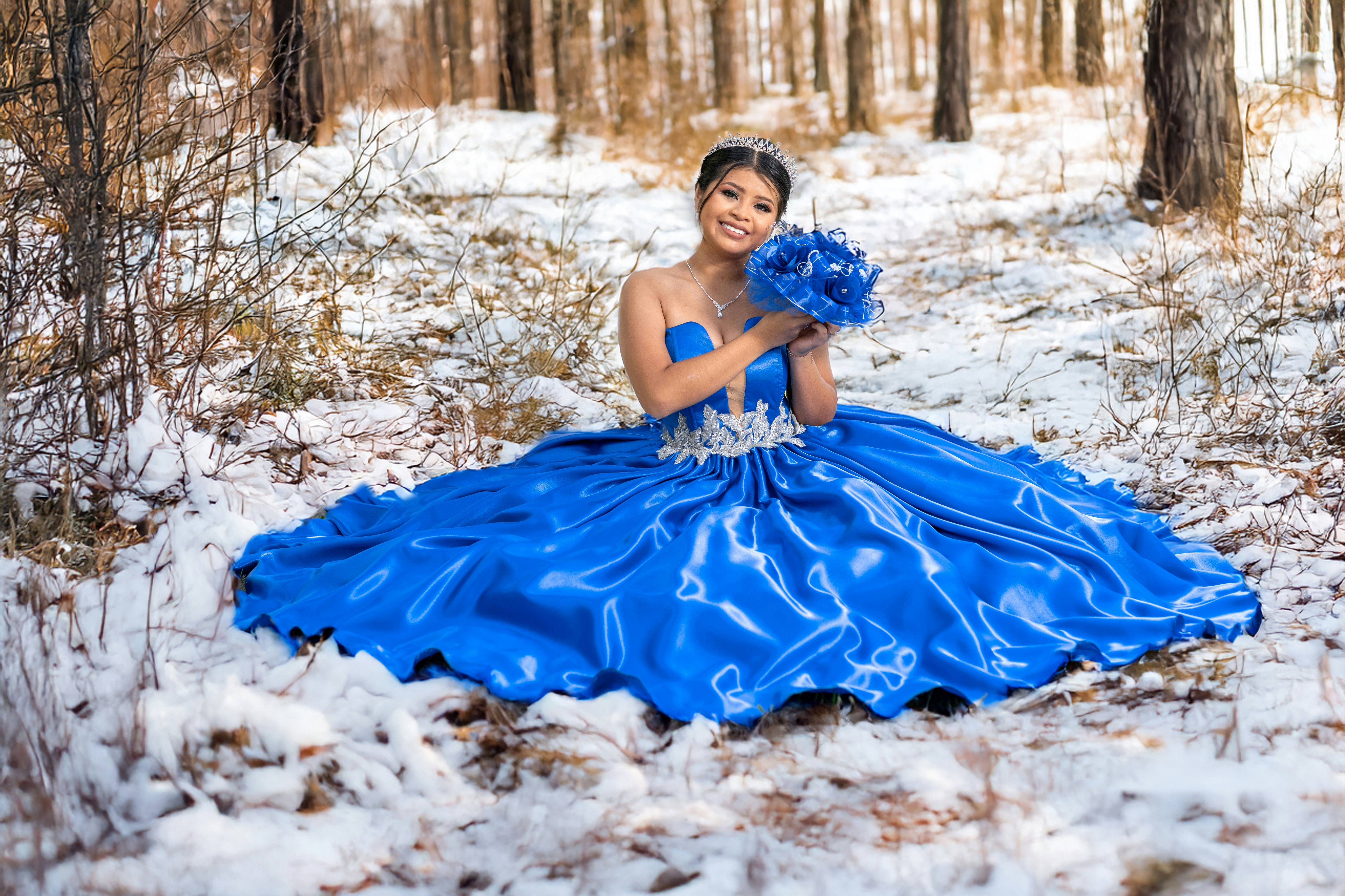 A woman in a blue dress sitting in the snow