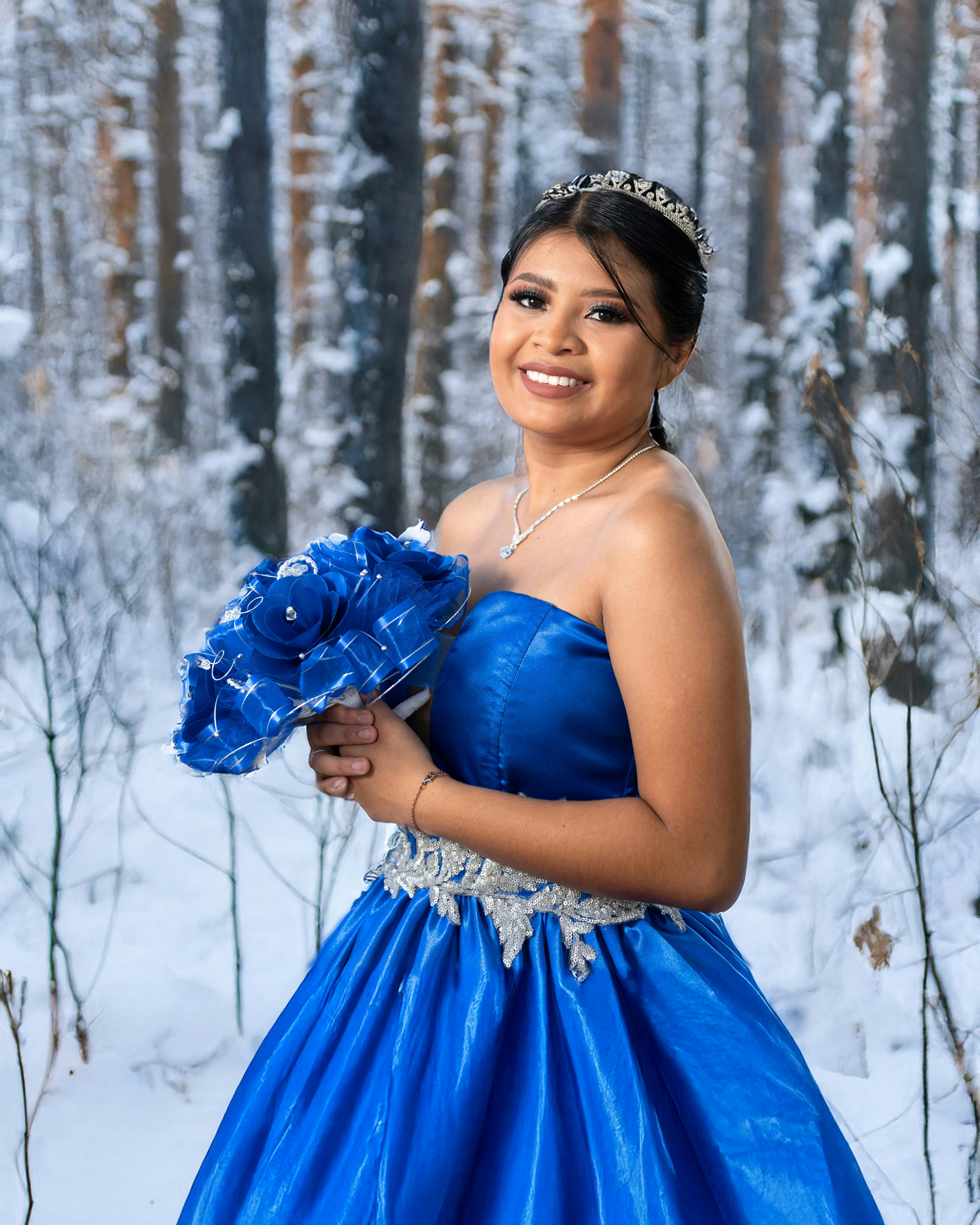 A woman in a blue dress standing in the snow