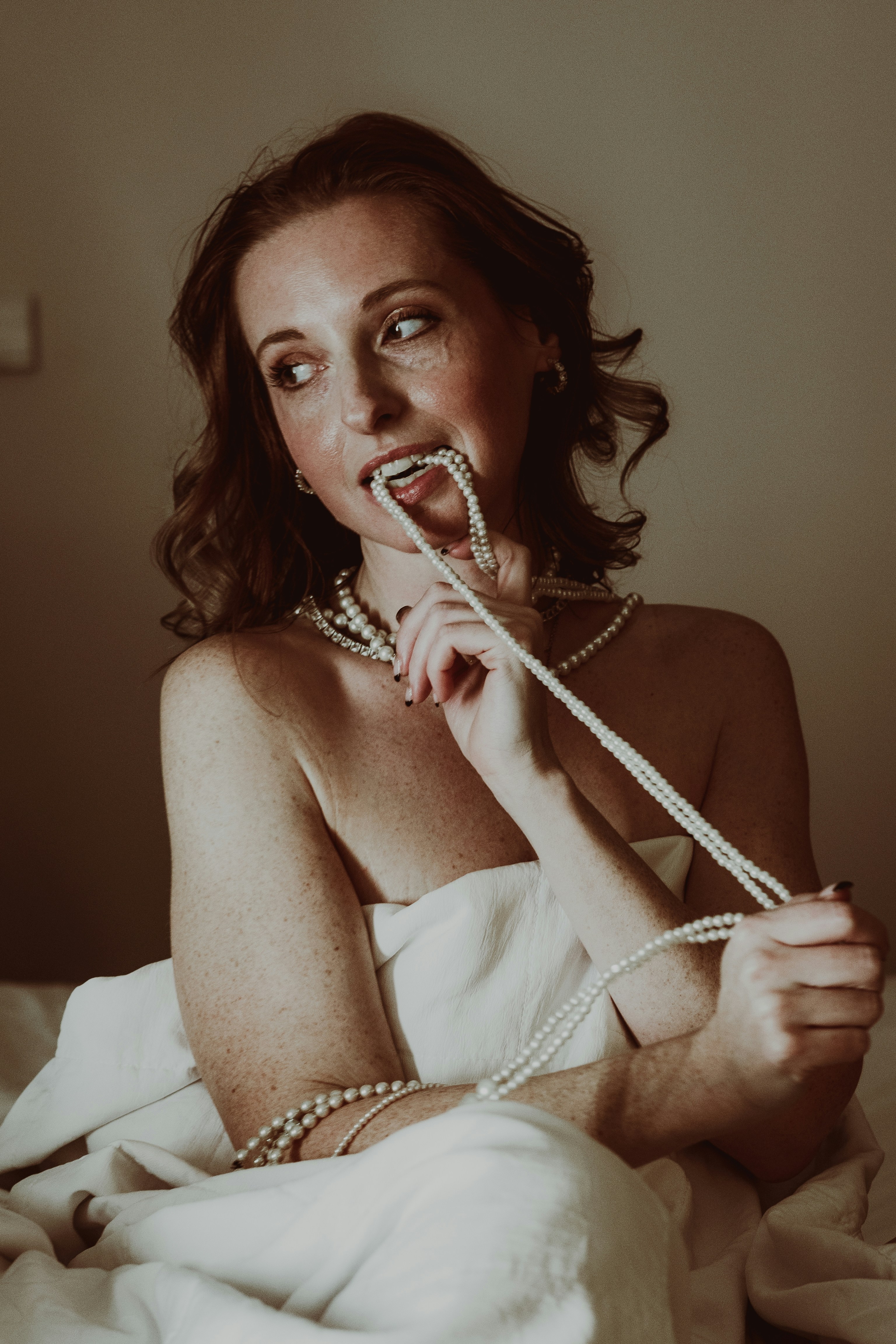 A woman in a bathrobe tied up to a bed