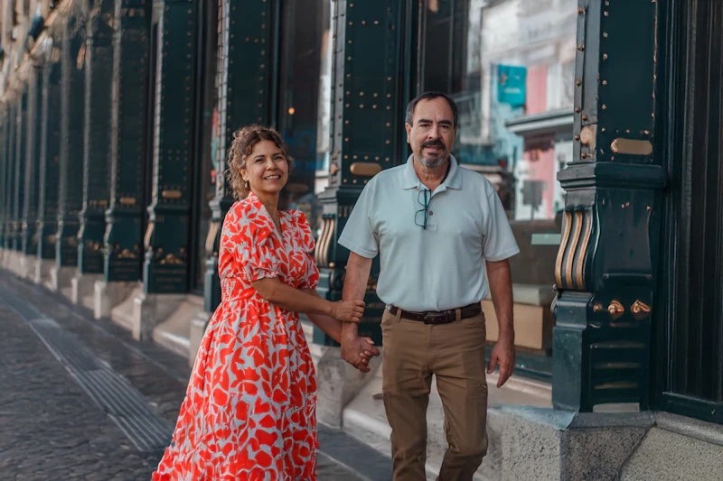 mature couple walking hand in hand down a street