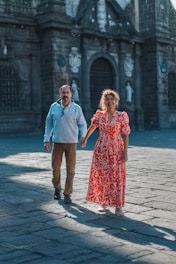 A man and a woman walking down a street holding hands