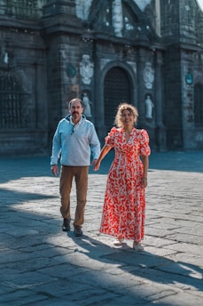 A man and a woman walking down a street holding hands
