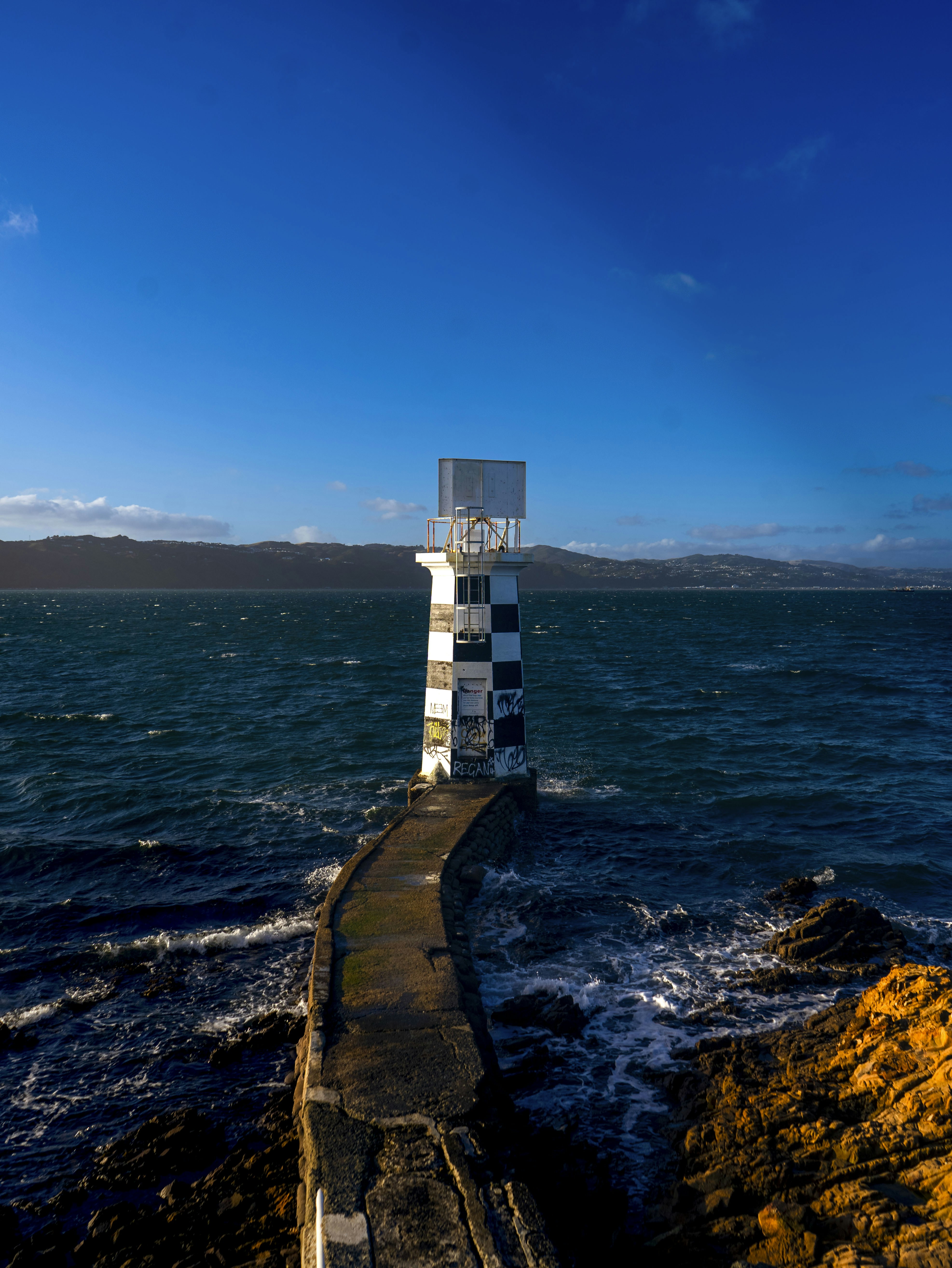 A lighthouse sitting on top of a rocky shore
