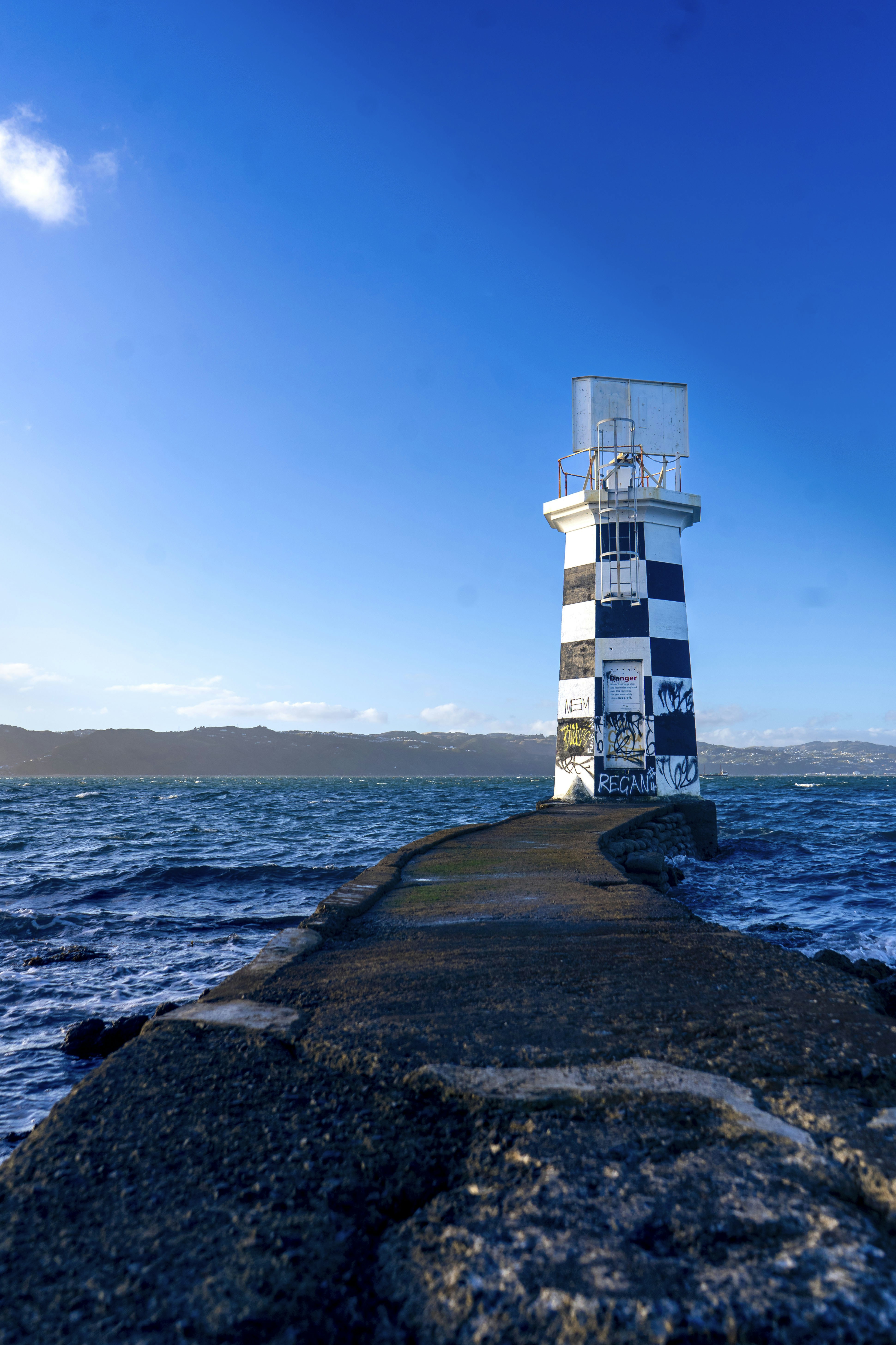 A white and blue lighthouse sitting on top of a pier