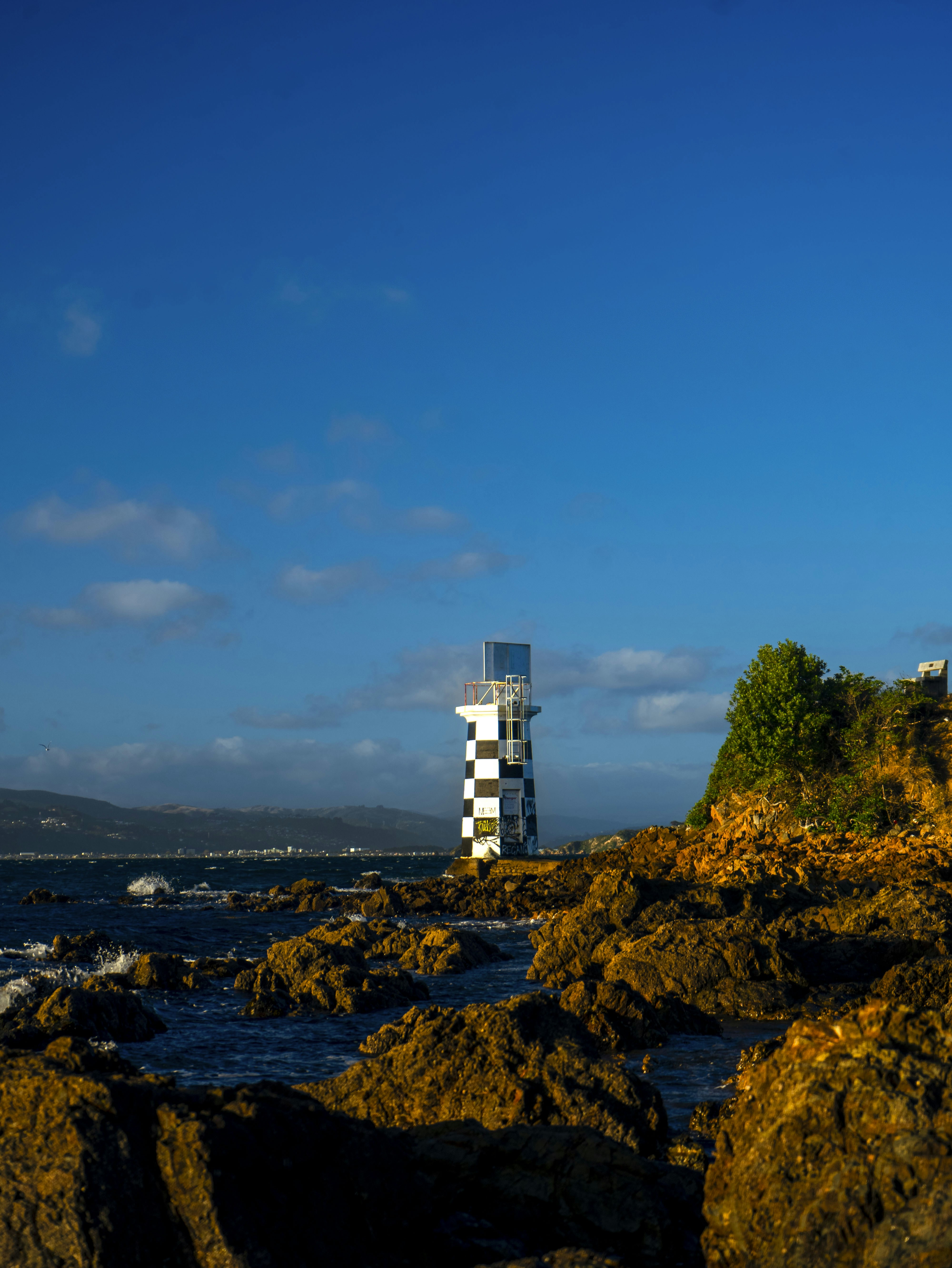 A tall tower sitting on top of a rocky beach