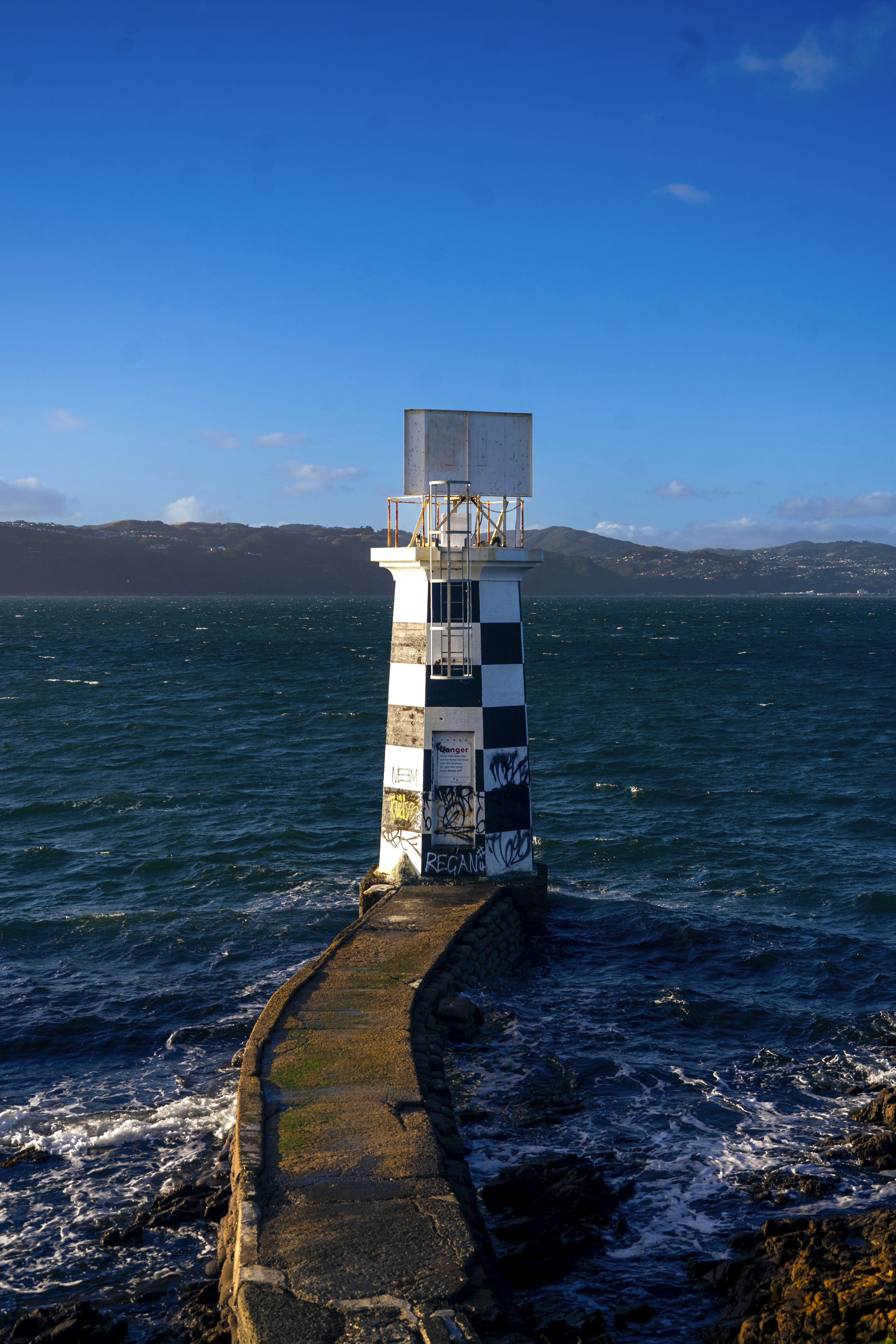 A light house sitting on top of a pier next to the ocean