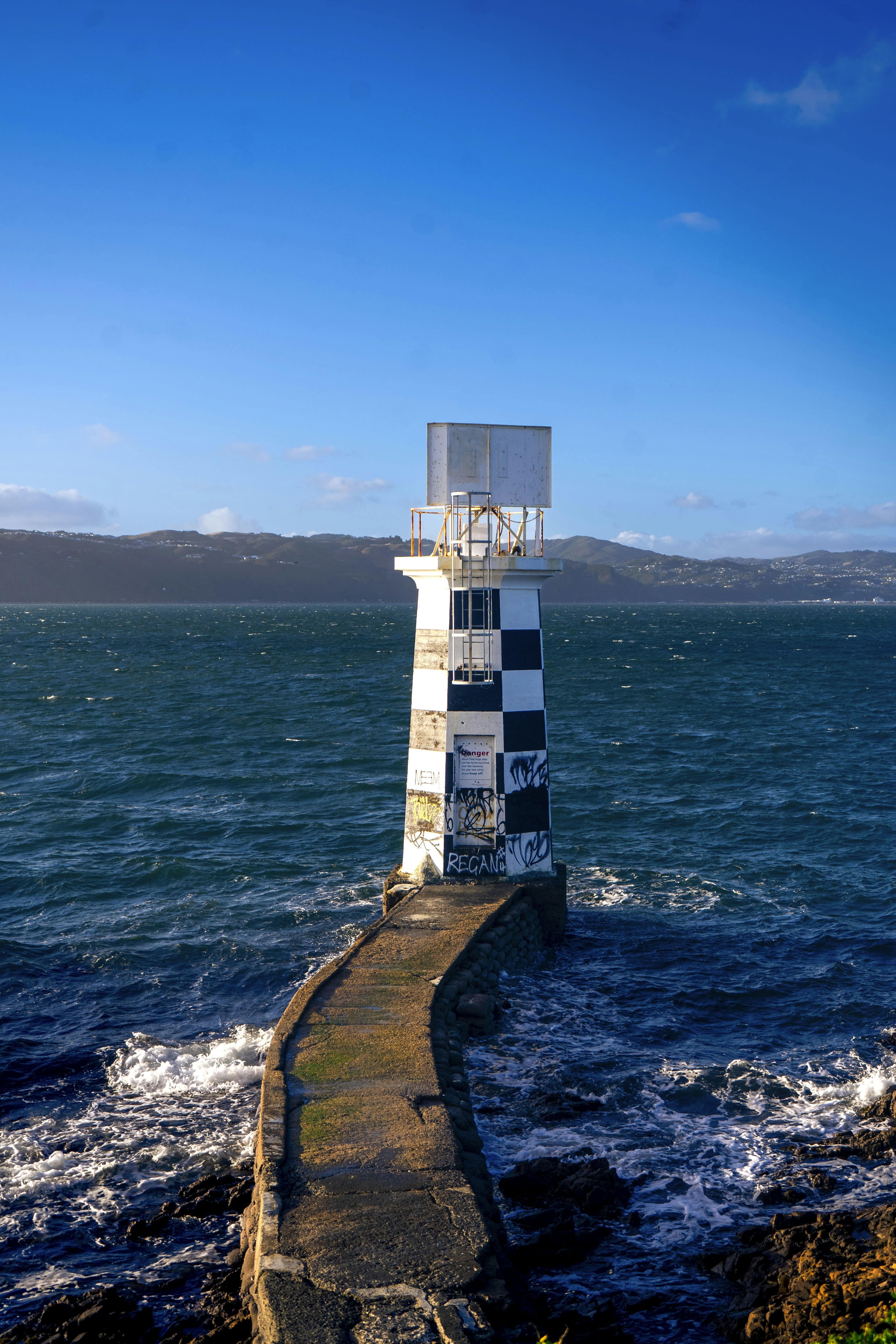 A lighthouse sitting on top of a rock near the ocean