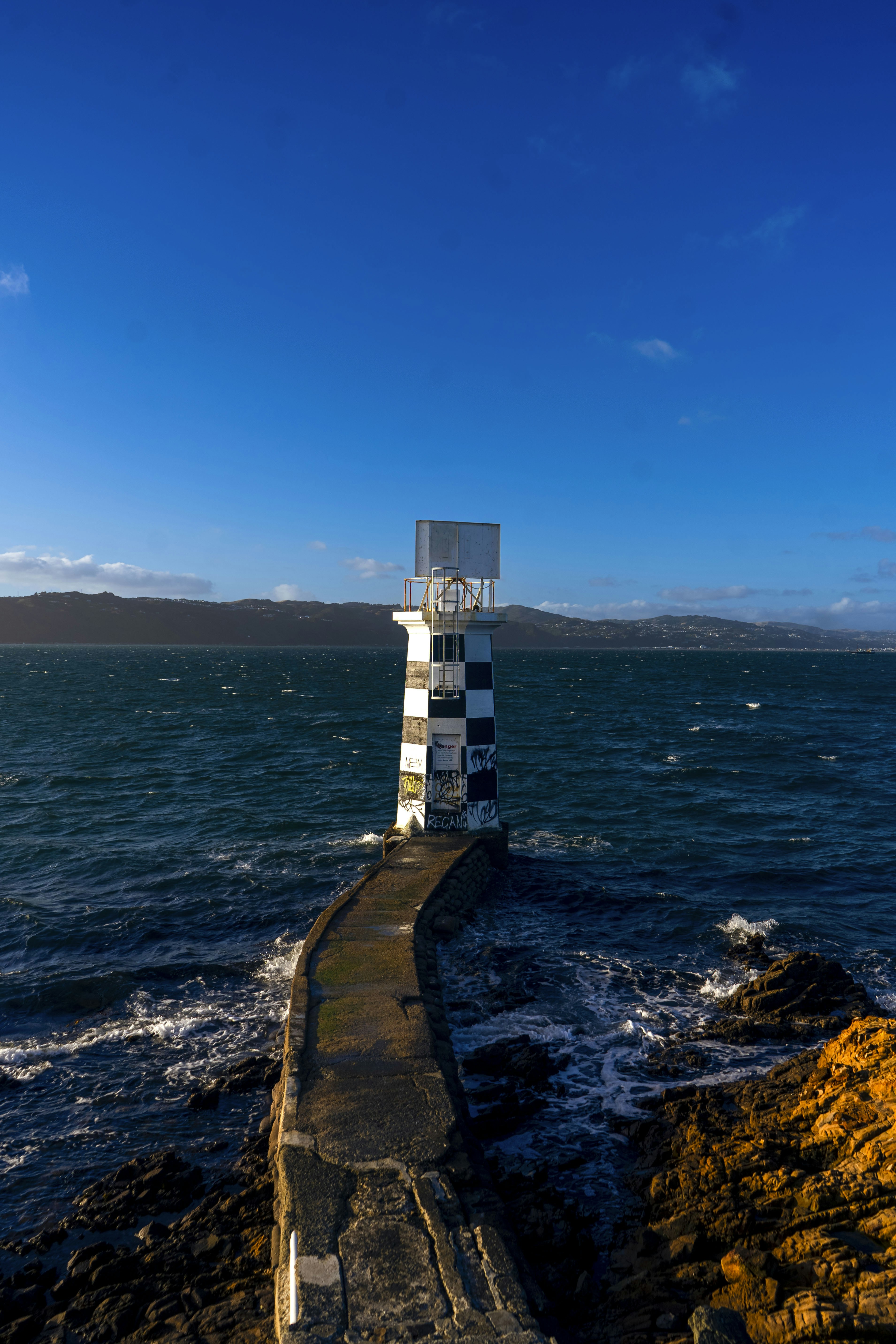 A lighthouse sitting on top of a rocky cliff next to the ocean
