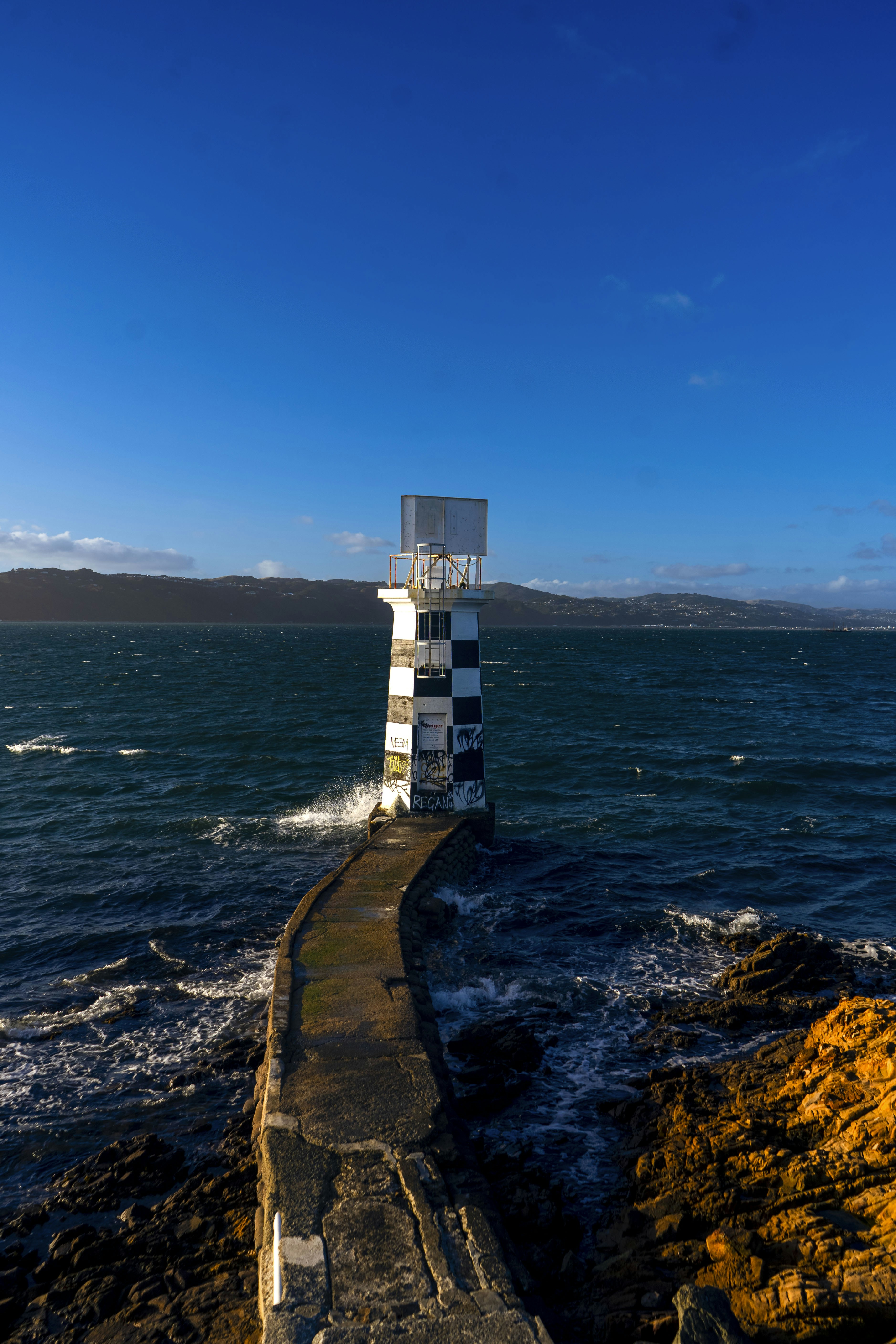 A lighthouse sitting on top of a rocky cliff next to the ocean