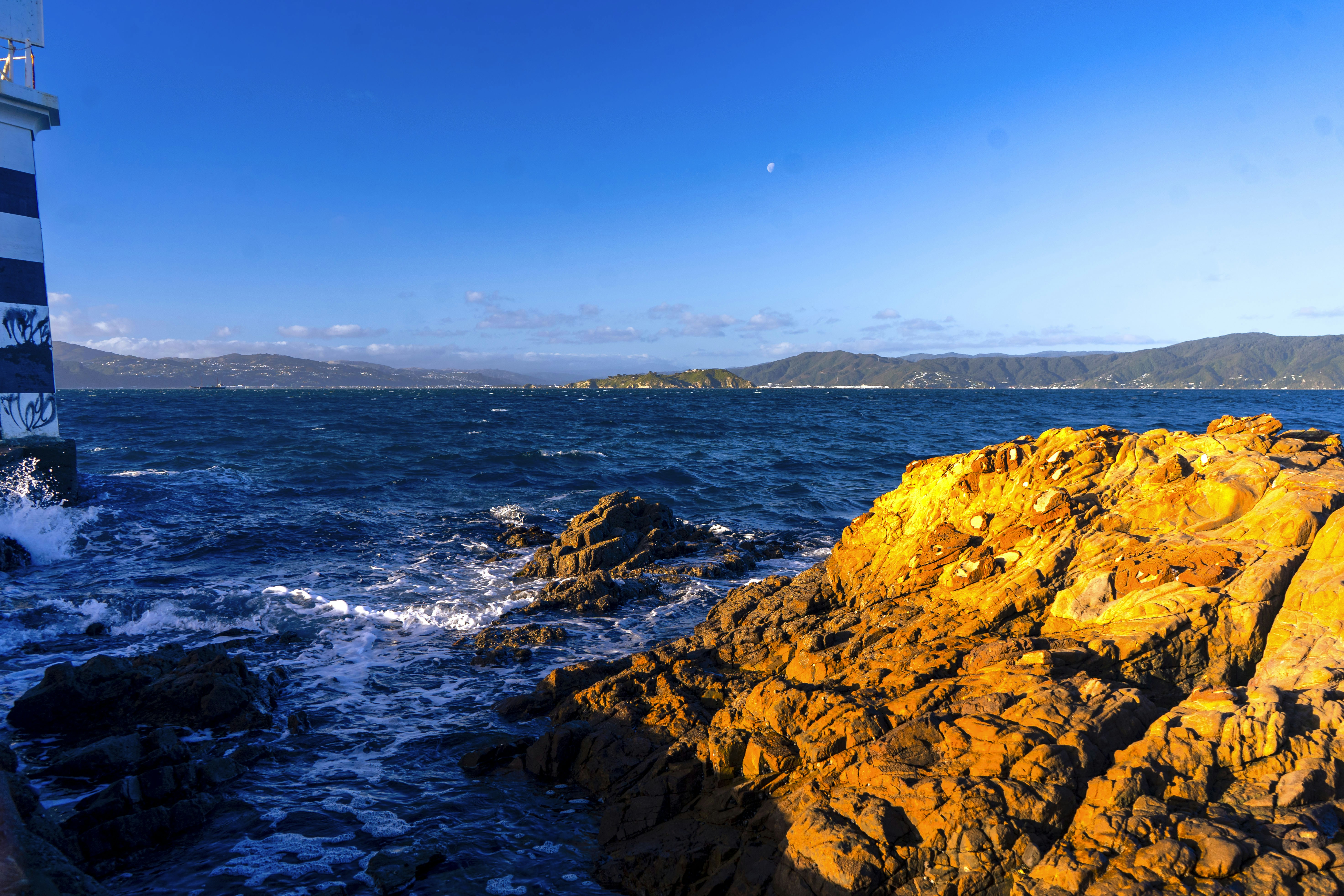 A lighthouse sitting on top of a rocky cliff next to the ocean