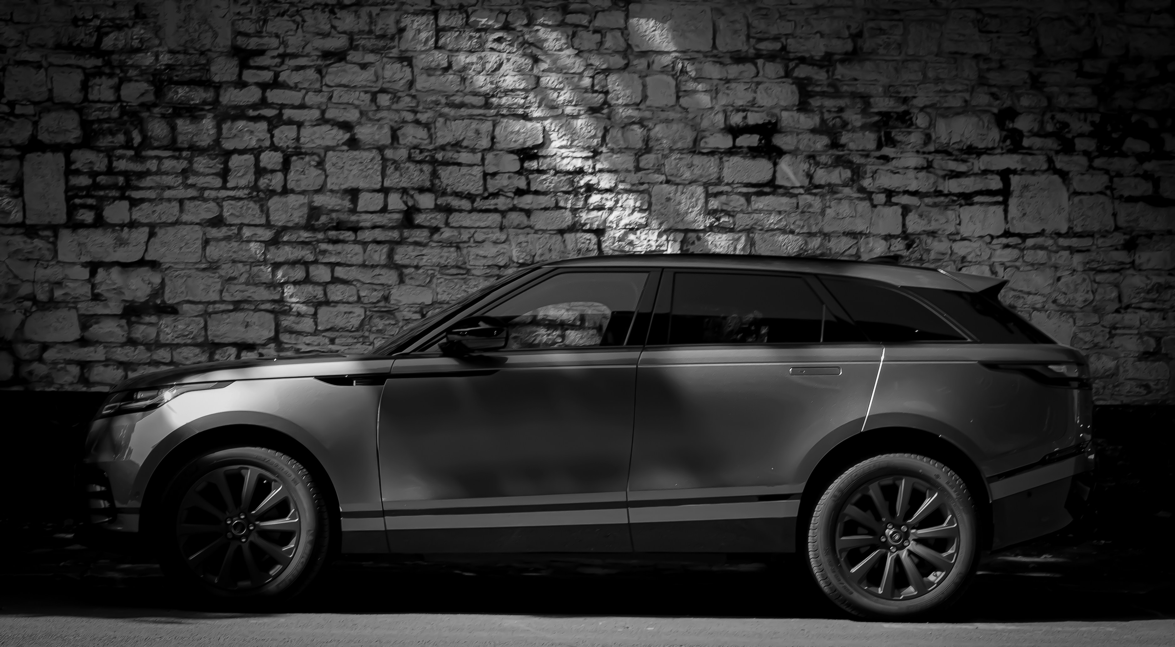 A car parked in front of a brick wall