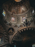 The ceiling of a church with stained glass windows