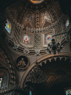 The ceiling of a church with stained glass windows