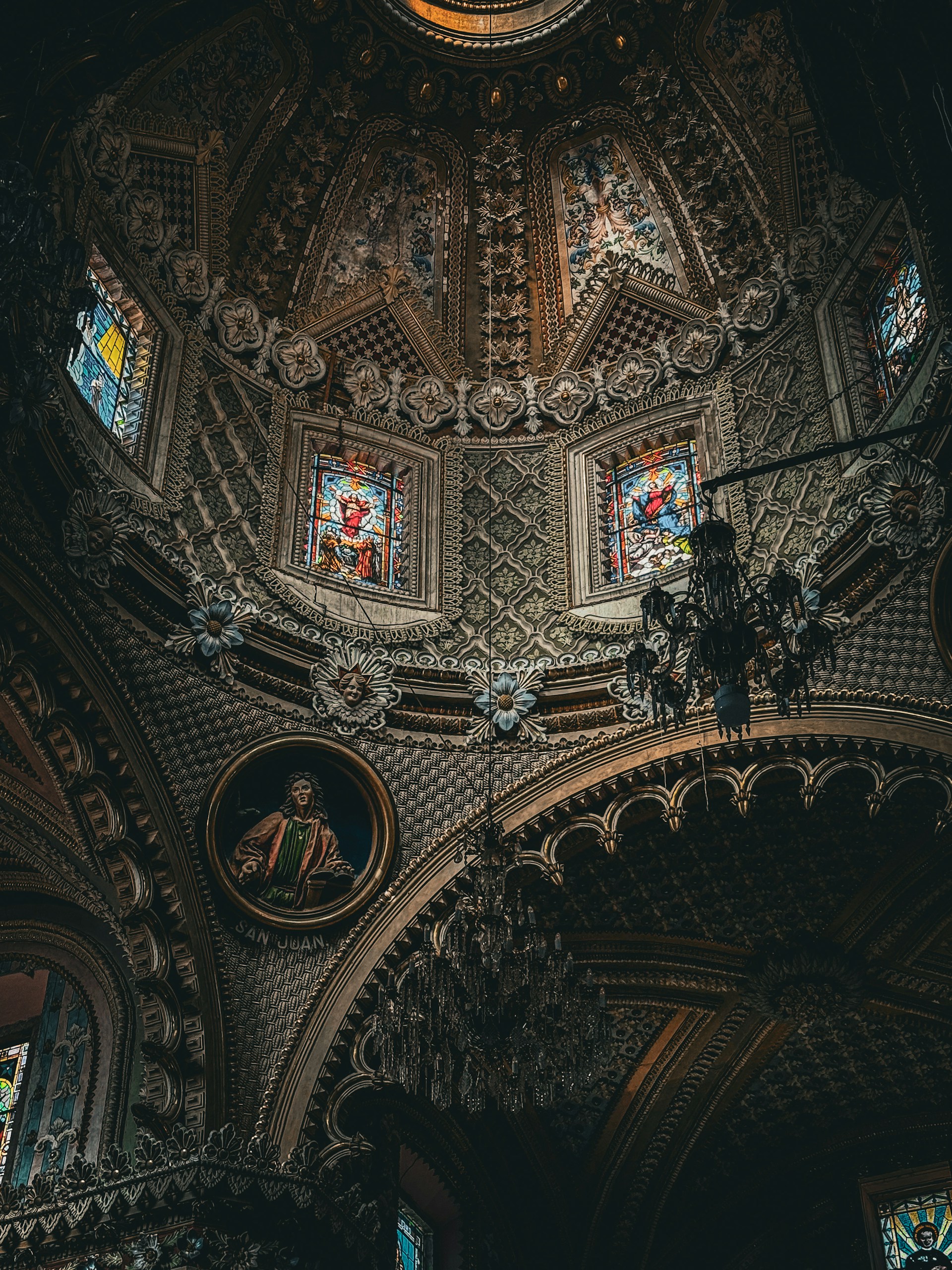 The ceiling of a church with stained glass windows