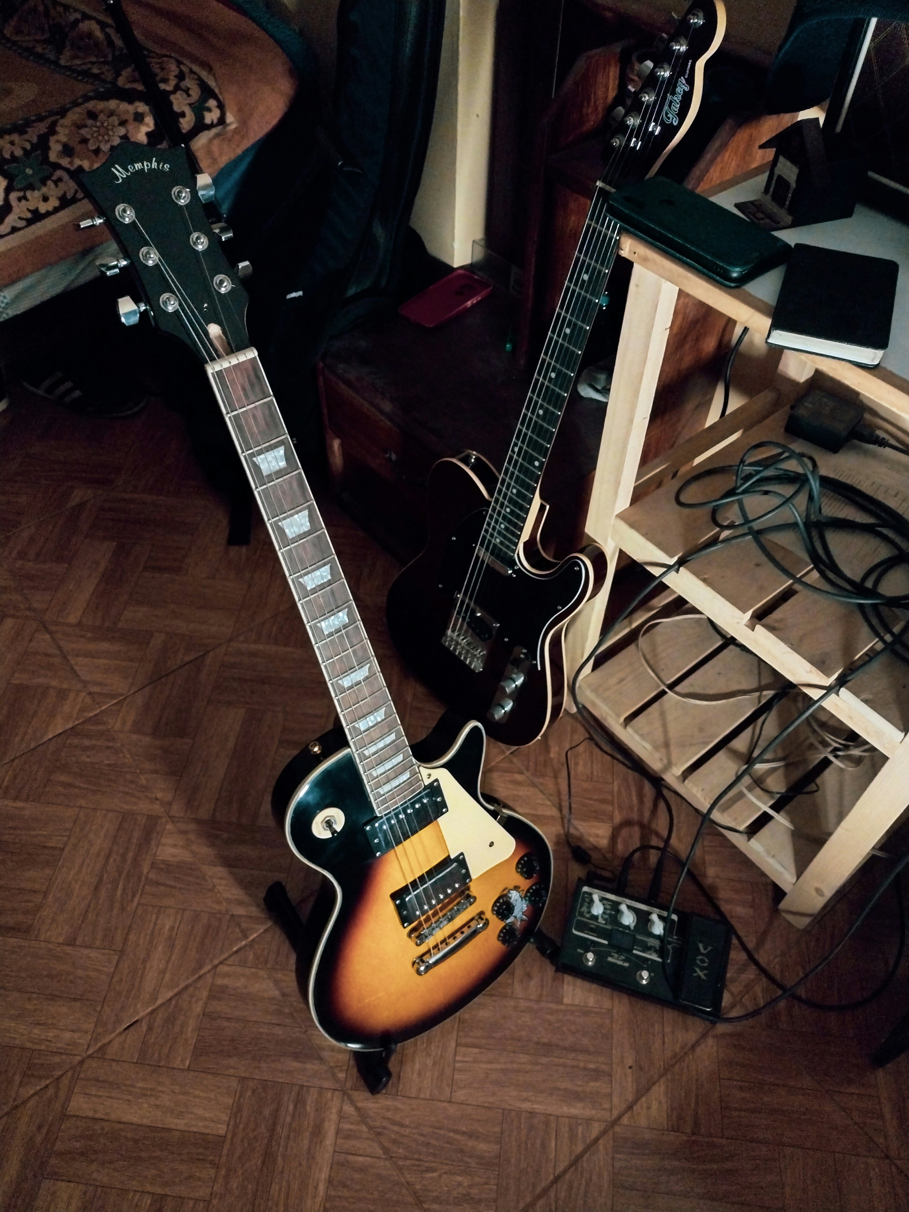 A guitar and other musical equipment sitting on the floor