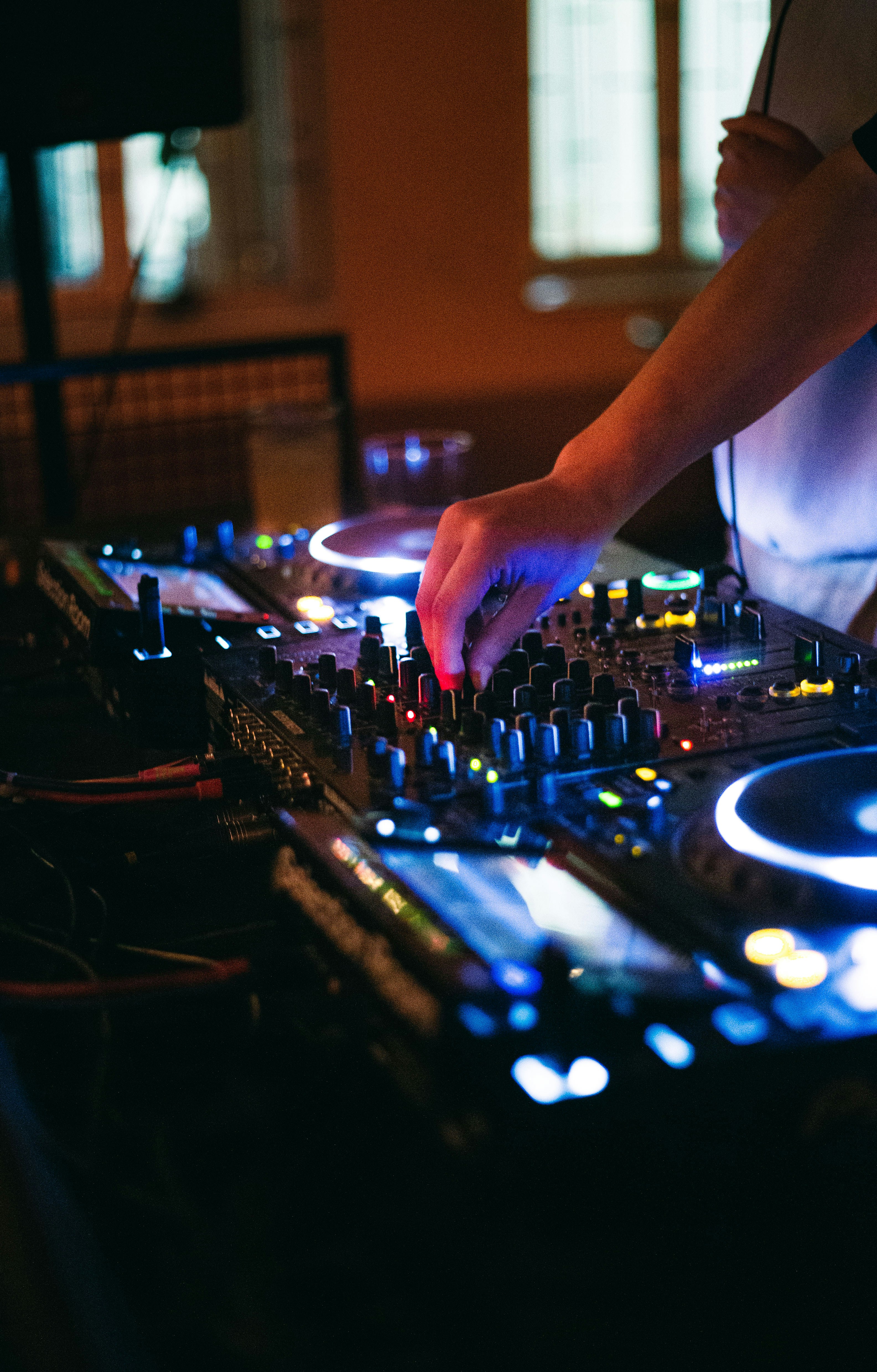 A dj mixing music in a dimly lit room
