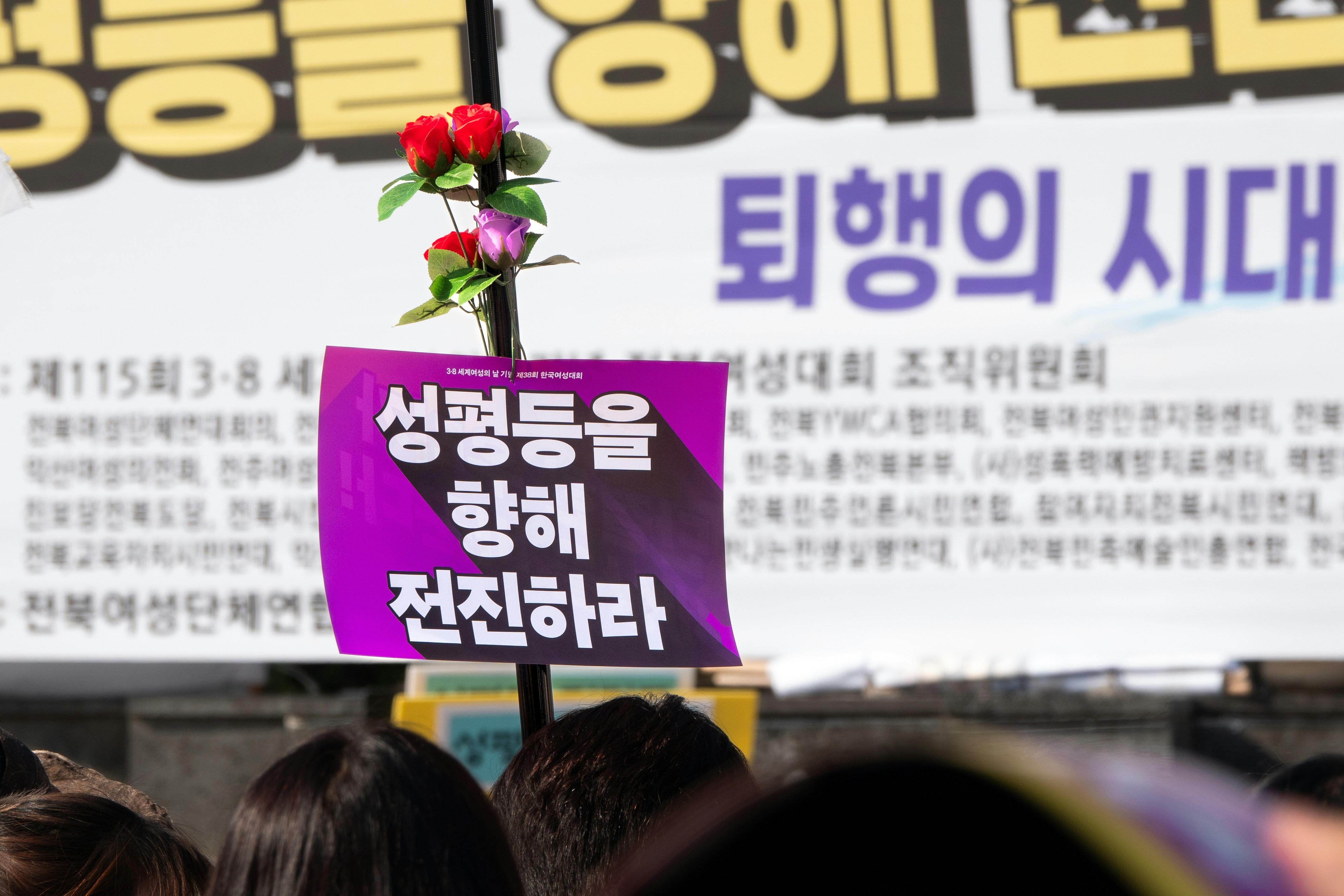 A group of people standing in front of a sign