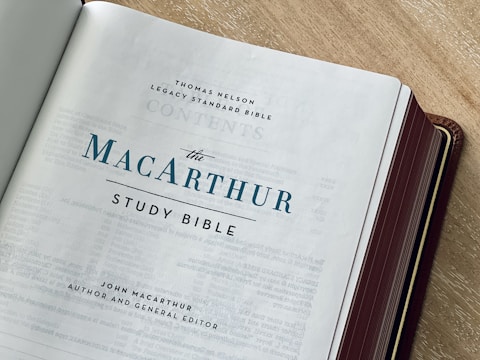 An open book on a table with a pen