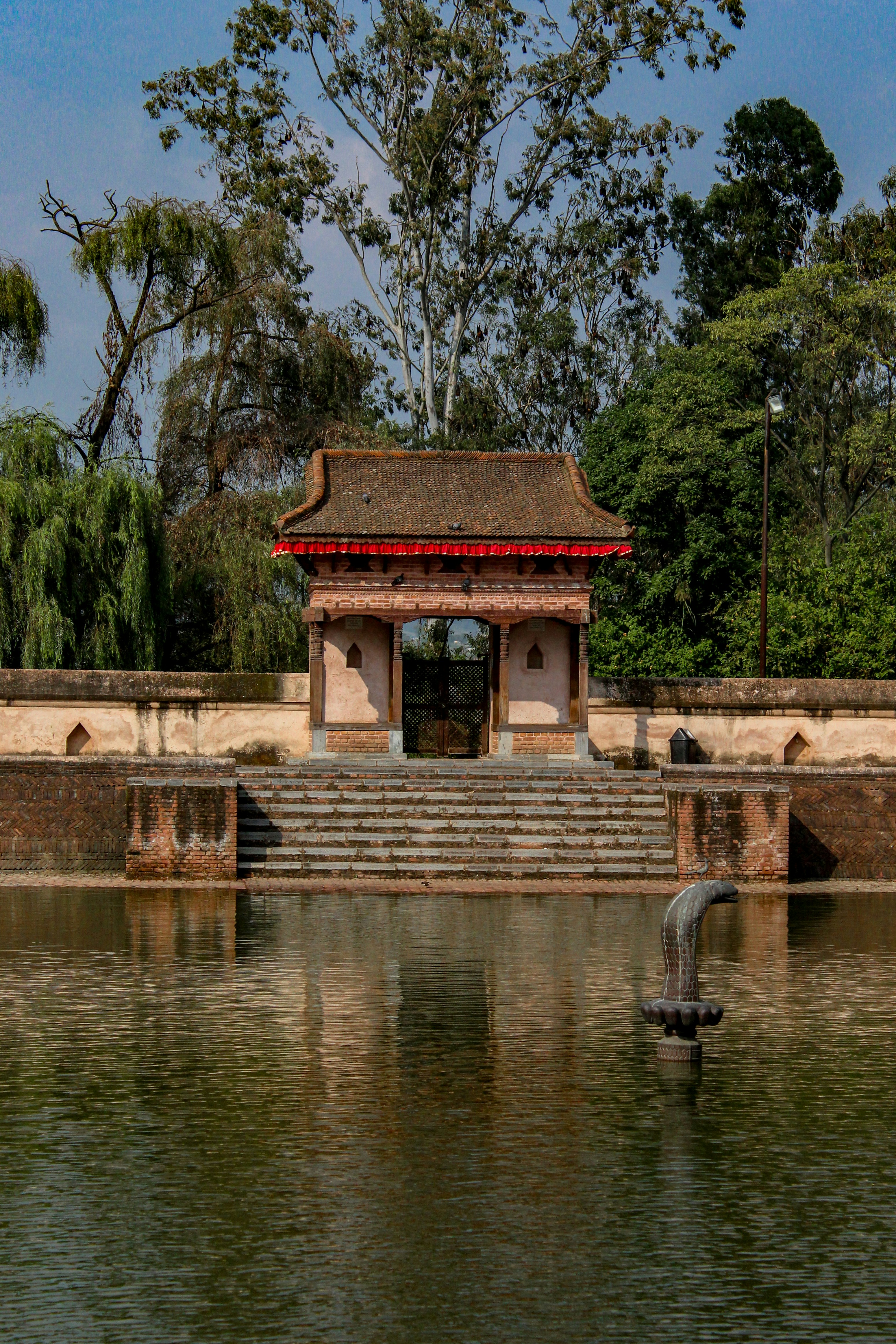 A pond with steps leading to a pavilion