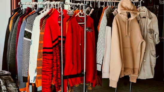 A rack of clothes in a closet with clothes hanging on it